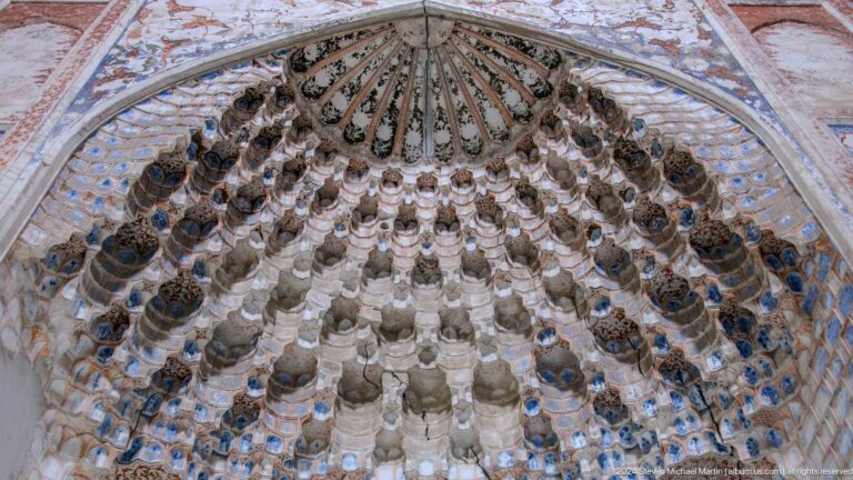 Dense gray muqarnas dome viewed upward.
