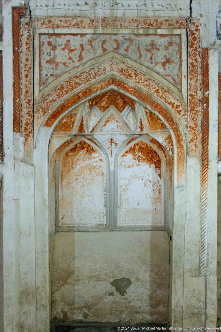 Faded plaster arches in shallow interior bay.
