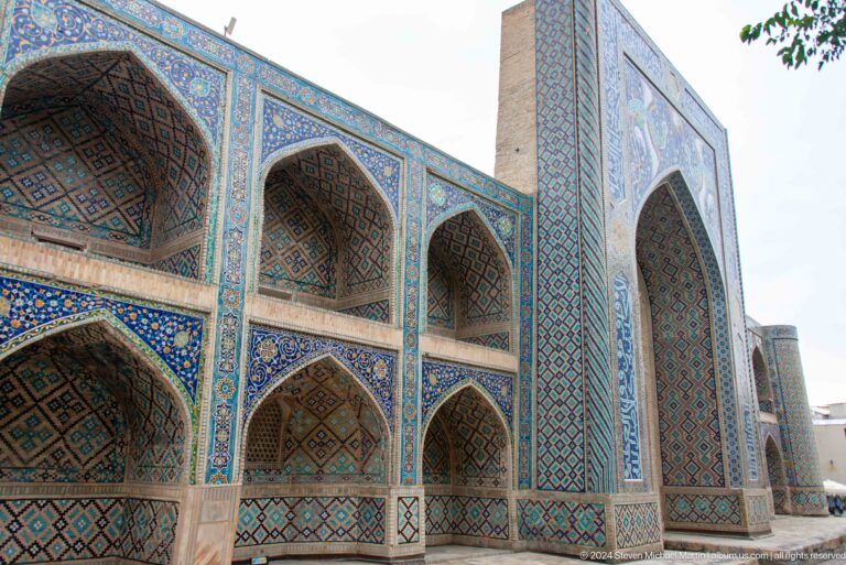 Large tiled madrasa facade seen from side.