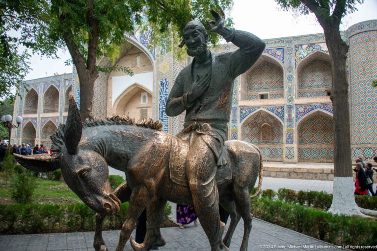 Bronze sculpture of folk character riding donkey.
