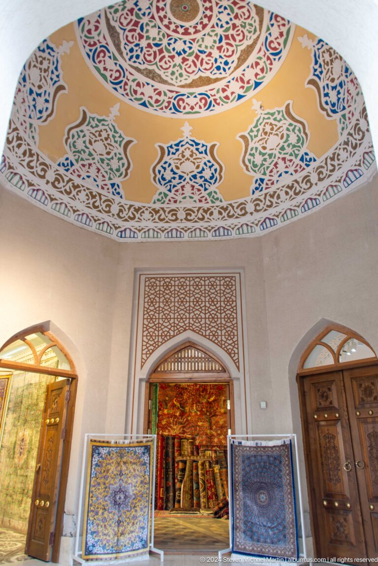 White interior wall with carved niches and painted frieze.