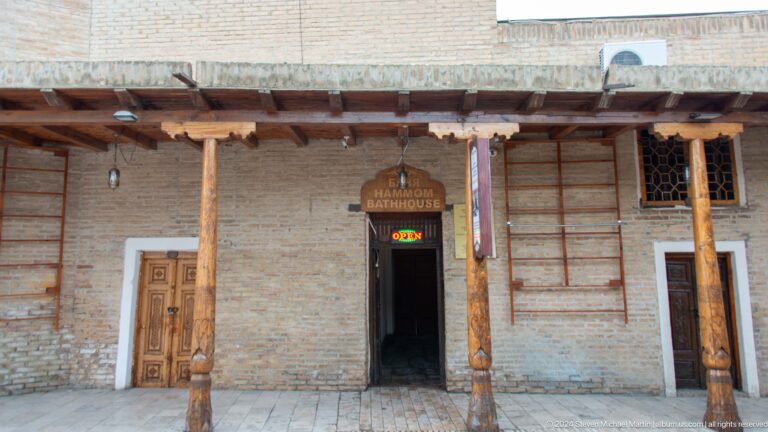 Timber-columned mud-brick shopfront.