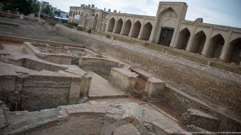 Excavated foundations beside arcade.