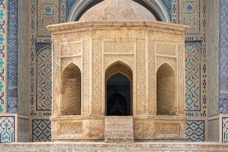Small ornate pavilion against tiled facade.