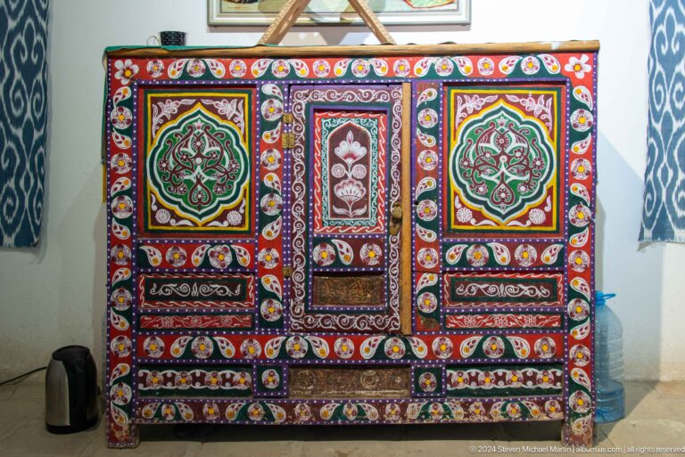 Embroidered wall hanging with three framed panels.