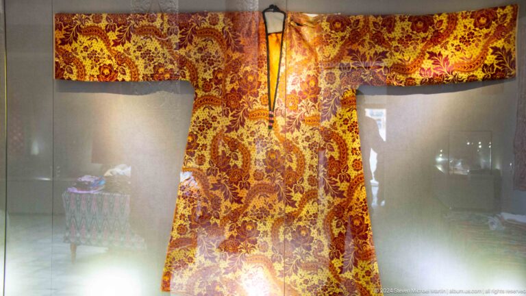 Richly patterned ceremonial robe in museum case.