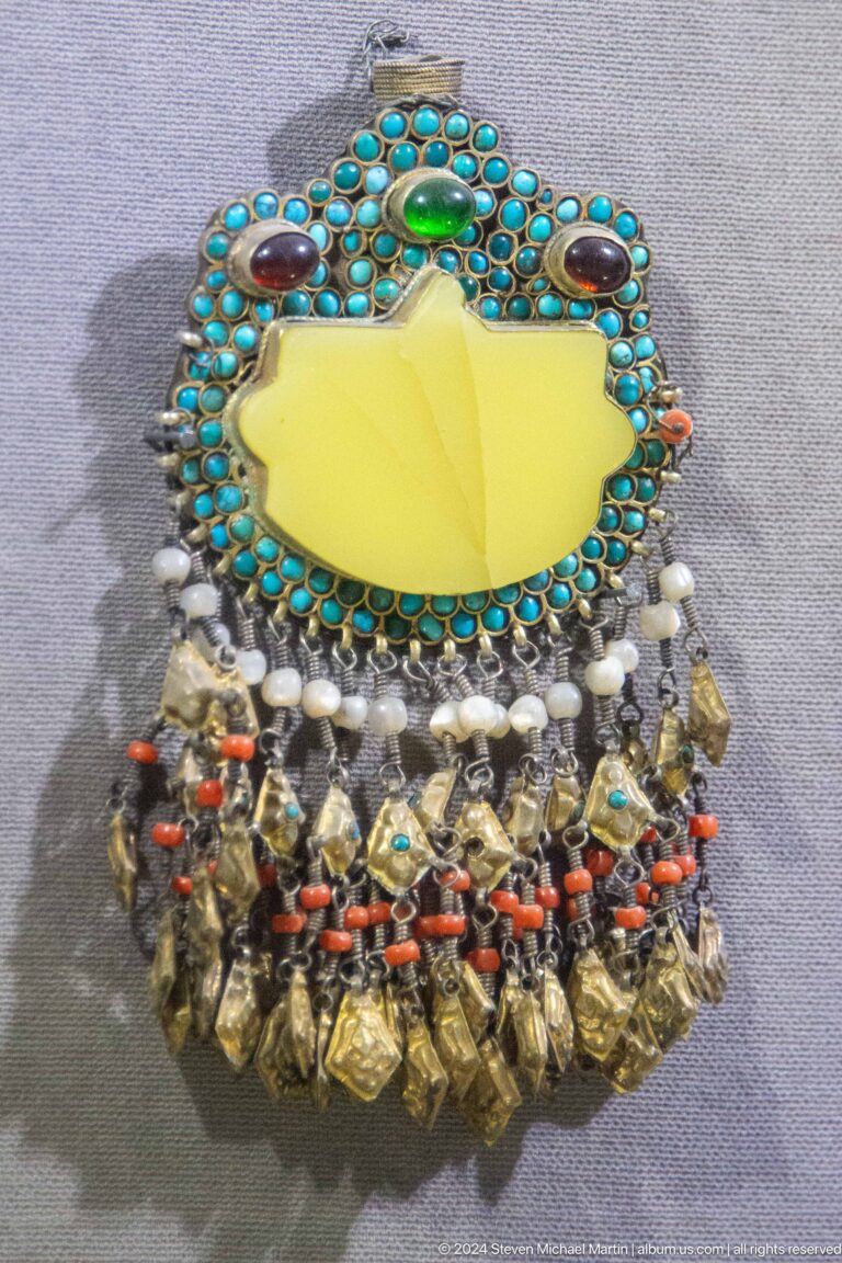 Silver necklace with turquoise beads and hanging charms.