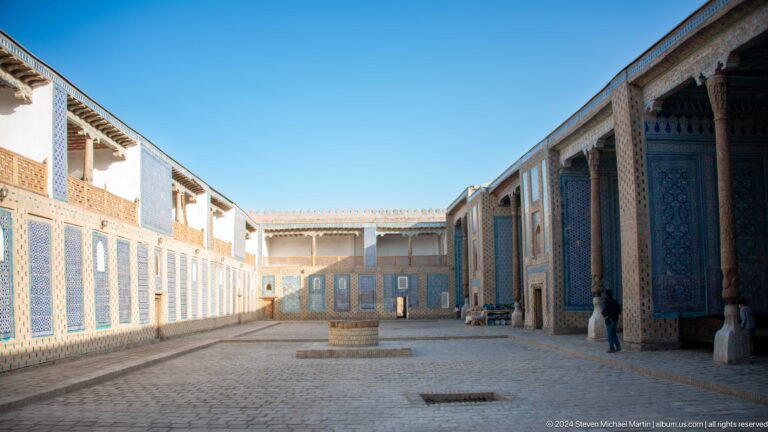 Empty blue-tiled palace courtyard in strong perspective.