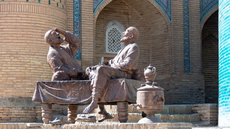 Bronze seated storyteller figures with tea service.