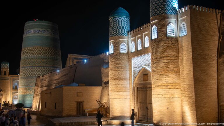Illuminated gate towers and kalta minor at night.