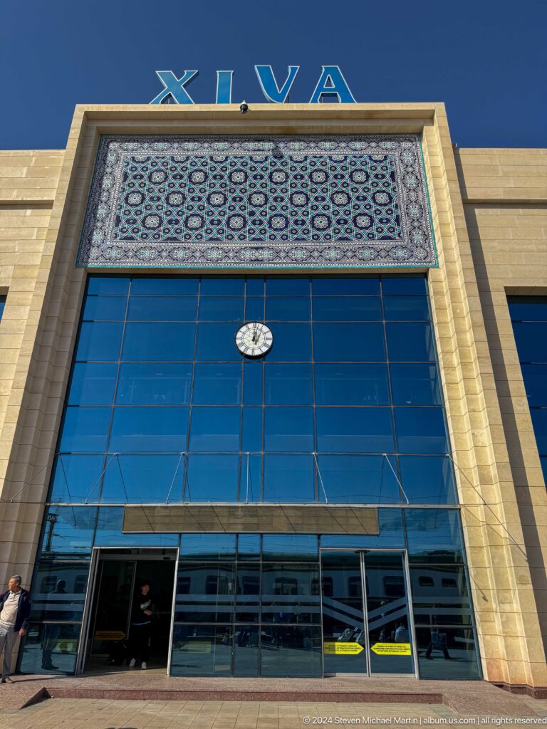 Modern building facade with blue glass and clock.