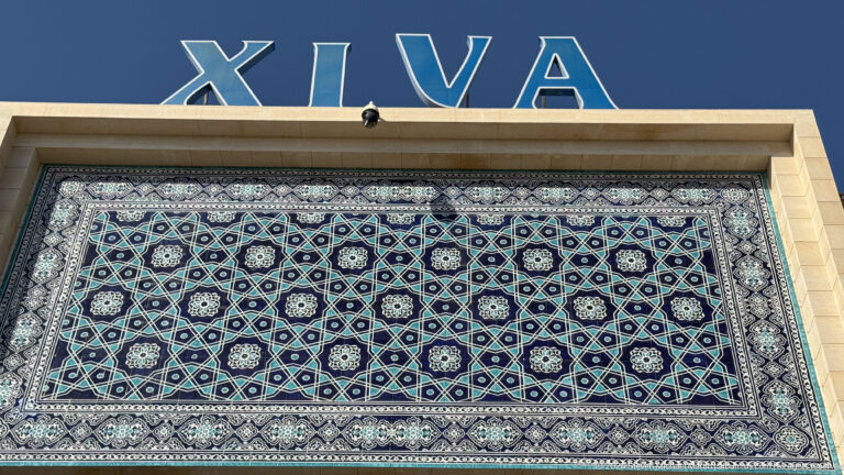 Decorative blue-and-white facade panel beneath large letters.