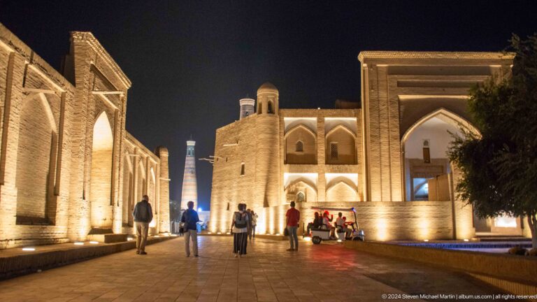 Busy floodlit street of monumental portals.