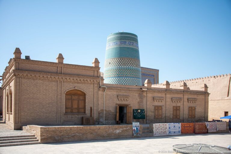 Low brick building with kalta minor behind it.