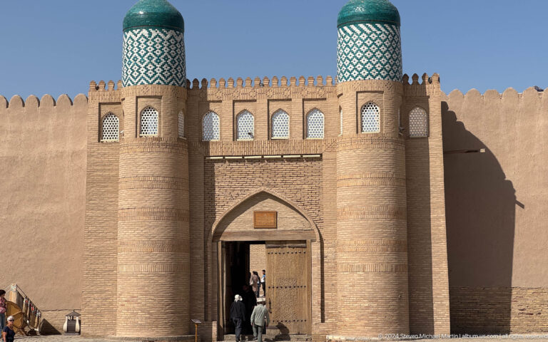 Historic gate with cylindrical turquoise-capped towers.