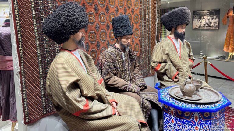 Wax figures in traditional robes around table.