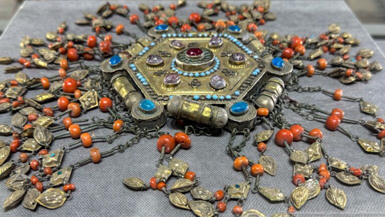 Ornate metal jewelry with red and turquoise stones.