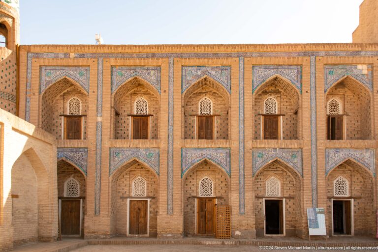 Two-story madrasa courtyard facade with repeated cells.