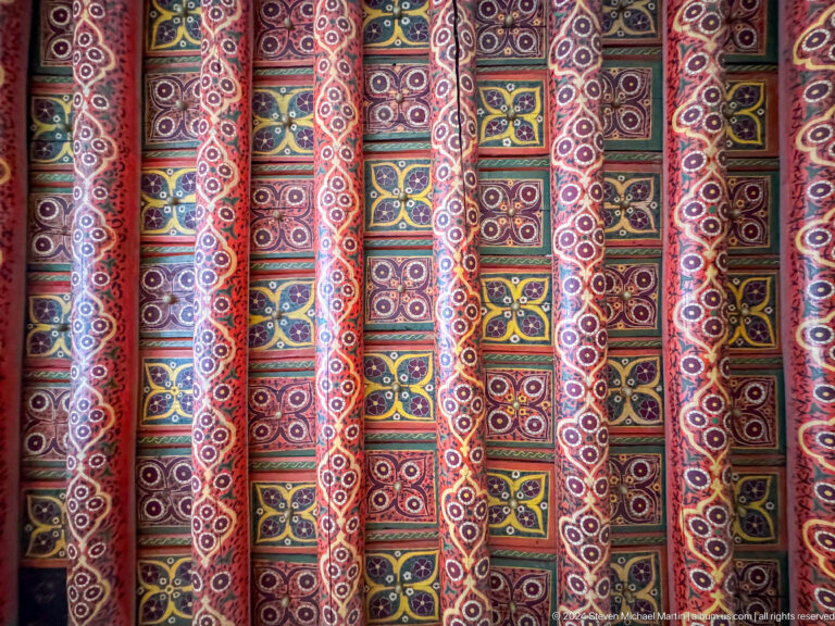 Rows of vividly patterned textile bolts.