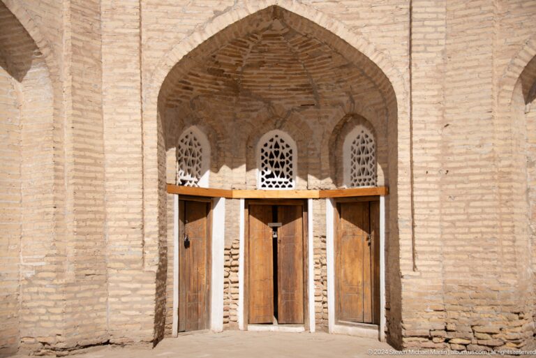 Recessed brick doorway beneath pointed arch.