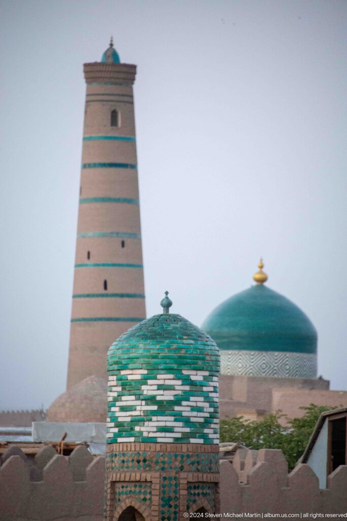 Islam khoja minaret framed with green domes.