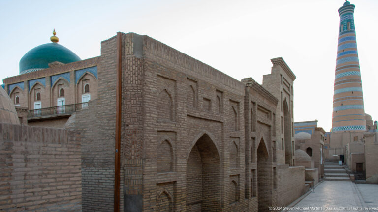 Narrow lane between monumental brick buildings.