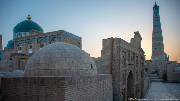 Domed roof and brick madrasa facade with minaret behind.