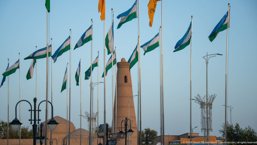 Uzbek flags flying beside a historic minaret.