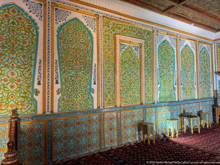 Painted green and gold wall panels in palace chamber.
