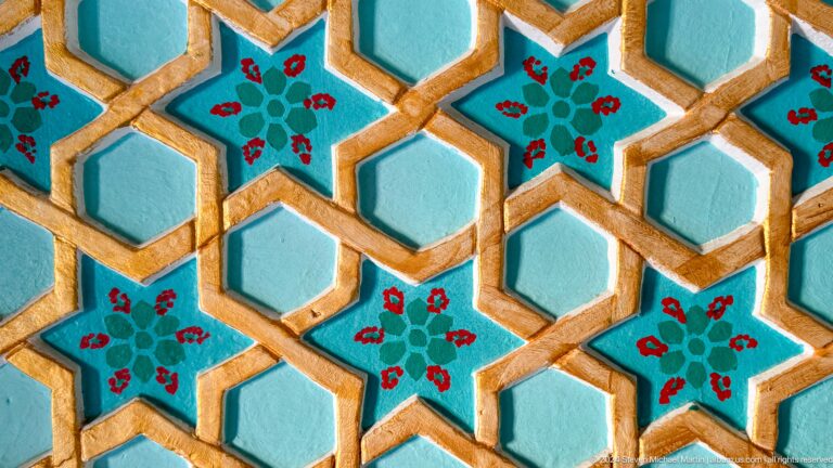 Turquoise hexagonal tile lattice with floral motifs.
