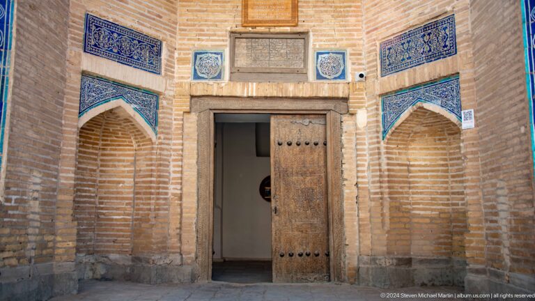 Historic wooden doorway framed by blue tile panels.