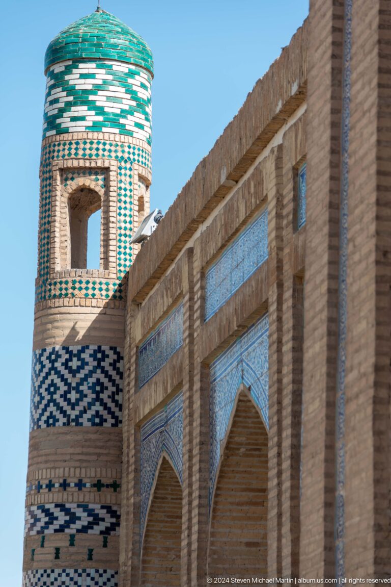 Brick minaret and wall faced with blue tile panels.