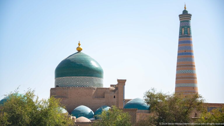 Green-domed mausoleum with islam khoja minaret behind.