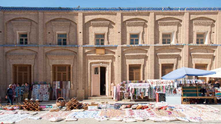 Market goods spread before a historic plastered facade.