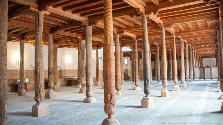 Sunlit rows of carved wooden columns.