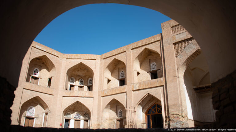Upper arcades of a brick madrasa courtyard.
