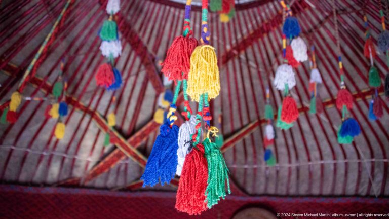 Bright tassels hanging from a yurt roof.