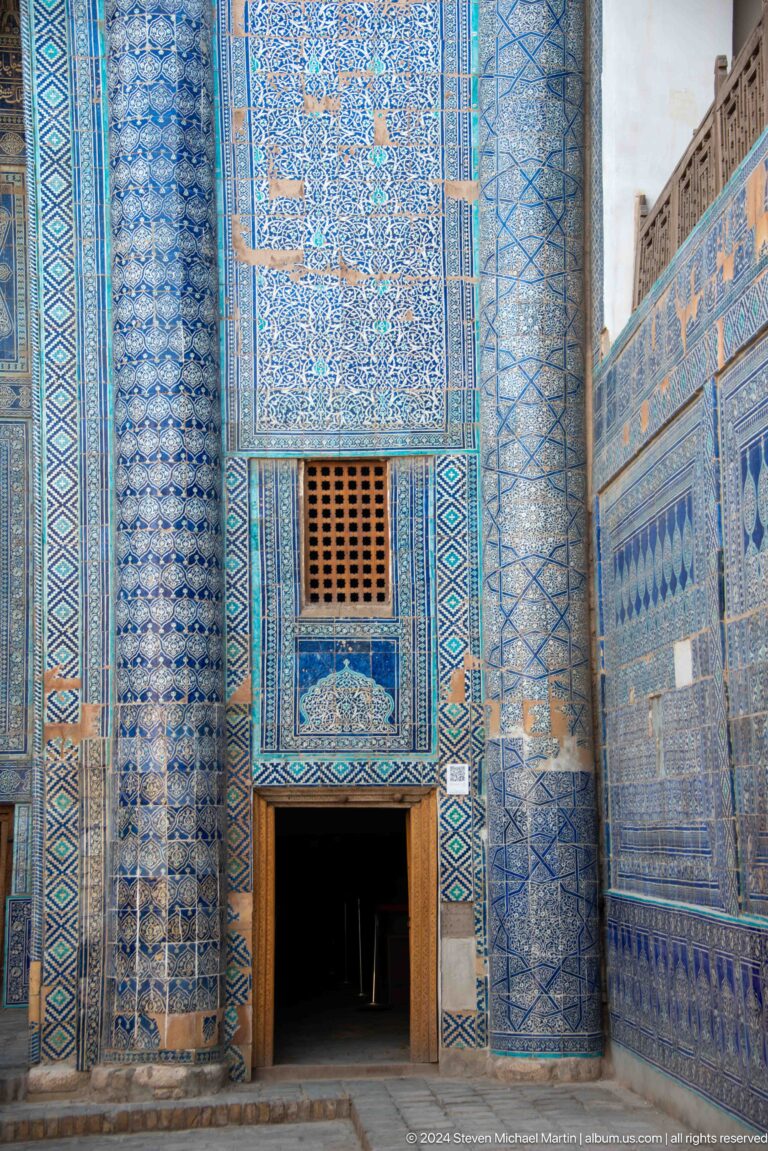 Blue-tiled wall with small lattice window.
