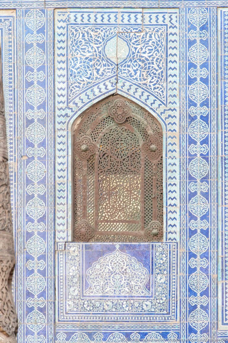 Carved wooden doorway framed by blue tiles.
