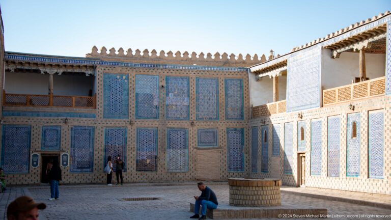 Broad palace courtyard surrounded by blue-tiled rooms.