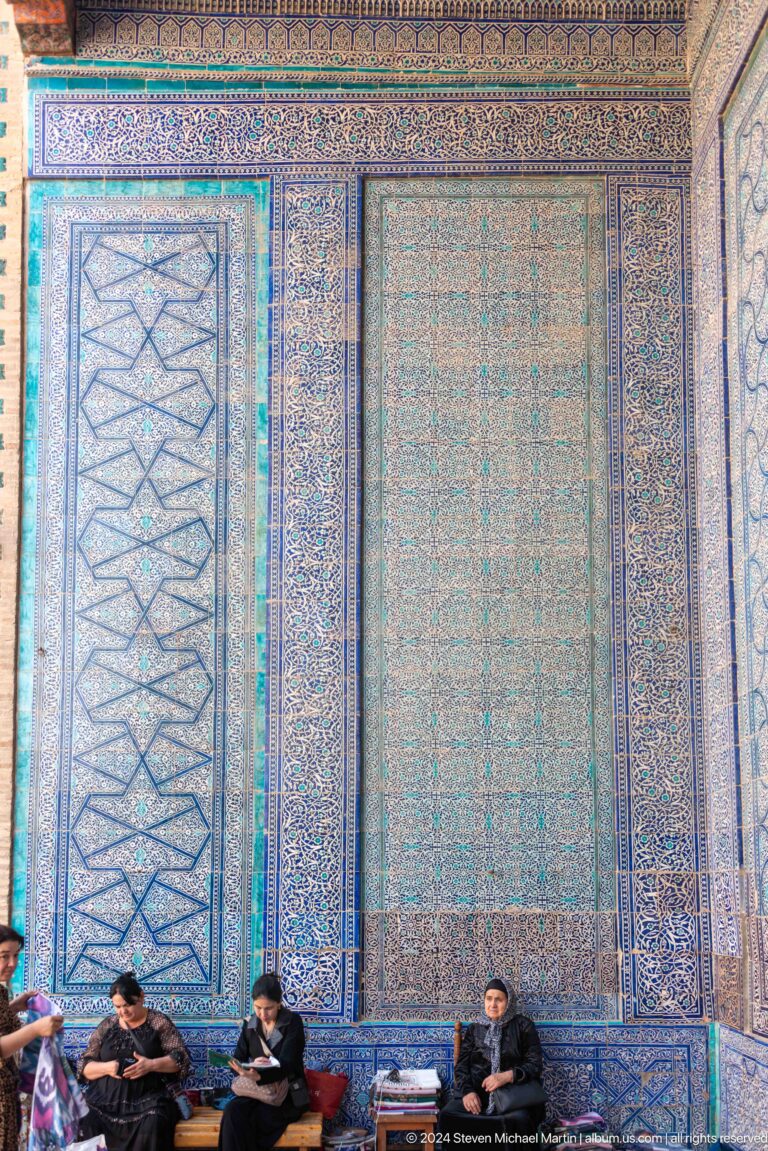 Close detail of faded blue geometric wall tiles.