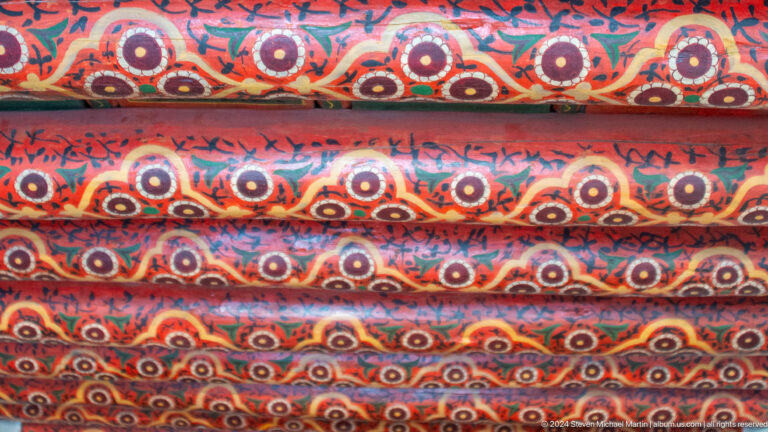 Red patterned woven textile close-up.