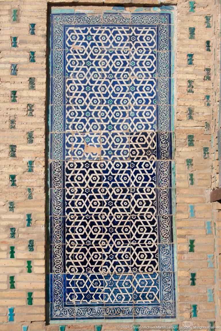 Blue geometric tile panel with interlaced pattern.