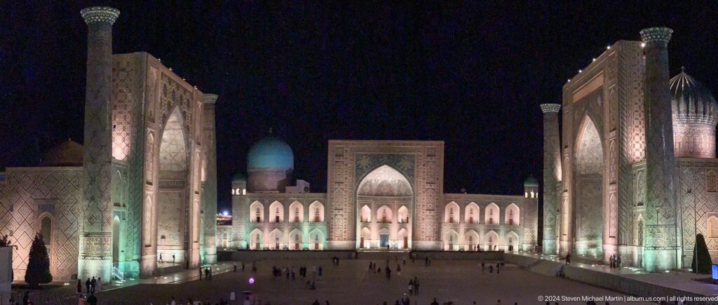 Centered night view of Tilya-Kori Madrasa framed by the side portals of Registan Square.