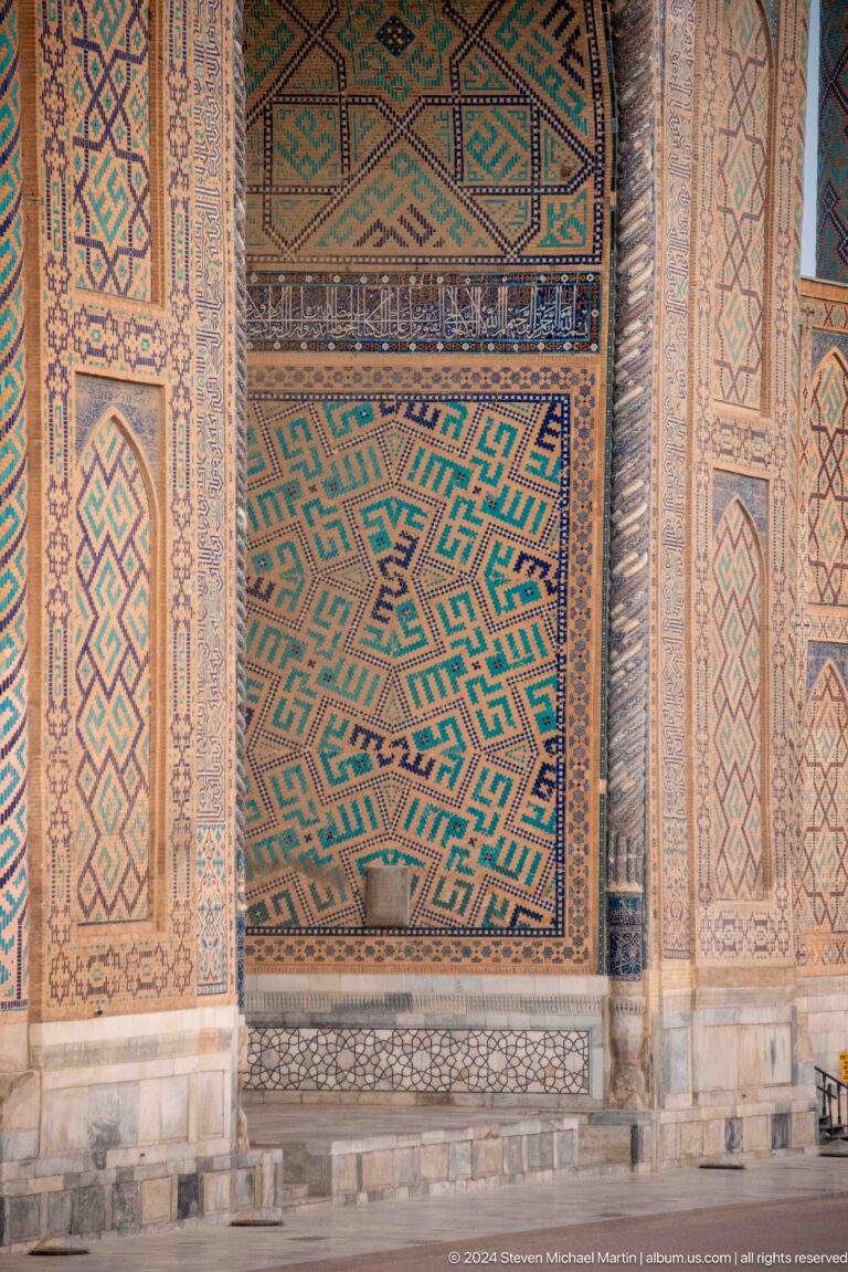 Close-up of interlocking turquoise, ochre, blue, and white geometric tilework.
