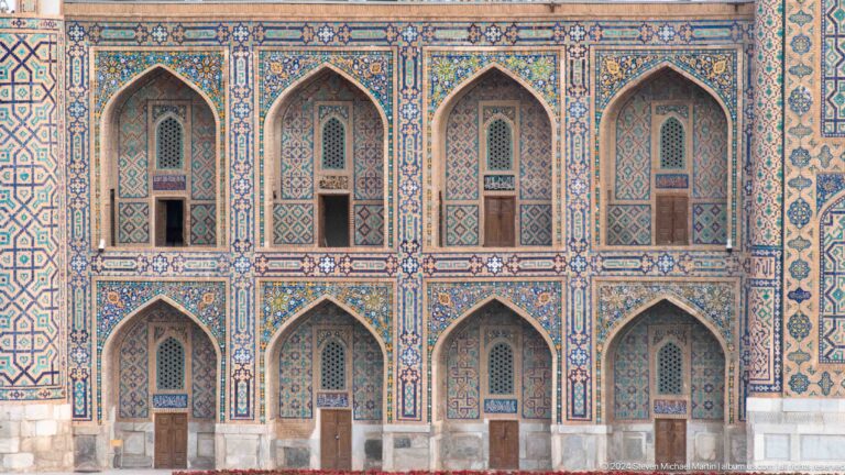Two-story arcade of repeated pointed arches framed with blue tilework.