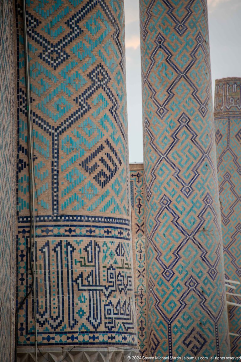 Close view of adjacent turquoise, blue, white, and ochre geometric tile panels.