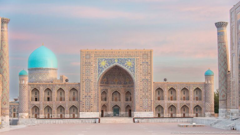 Closer frontal view of Tilya-Kori Madrasa with central tiled portal, arcades, and turquoise domes.