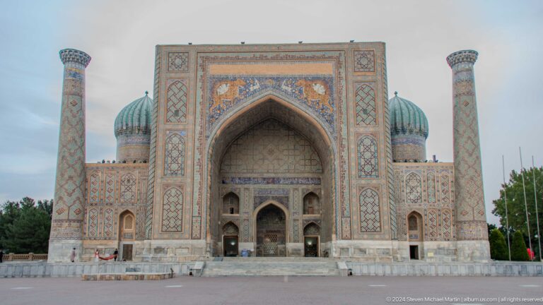 Frontal view of Sher-Dor Madrasa with animal mosaics, ribbed turquoise domes, and minarets.
