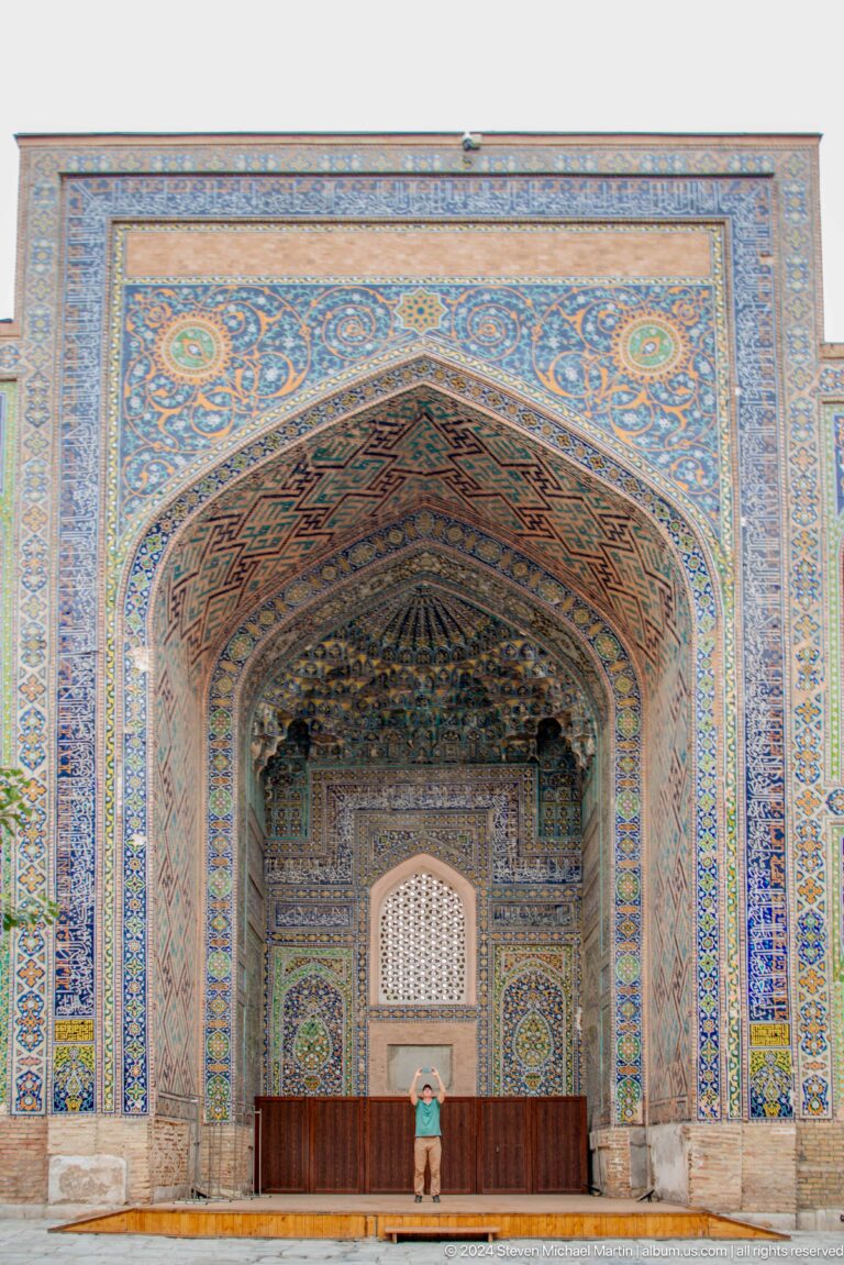 Full view of a pointed portal vault with muqarnas and blue-and-ochre ornament.